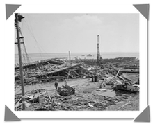 Black and white image of a shipyard after an explosion with wreckage strewn about